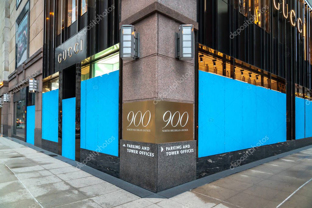 Chicago, IL - April 22nd, 2020: The Gucci store at 900 North Michigan Avenue has its doros and windows boarded up with blue plywood as they close during the COVID-19 pandemic and stay at home orders.