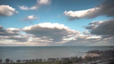 Şikago, IL - 4 Nisan 2018: Cumulus bulutları Michigan Gölü 'nün suları üzerinde hareket ederken aşağıdaki Lake Shore Drive' da araç trafiği hızlanır..