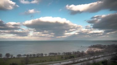 Şikago, IL - 4 Nisan 2018: Cumulus bulutları Michigan Gölü 'nün suları üzerinde hareket ederken aşağıdaki Lake Shore Drive' da araç trafiği hızlanır..