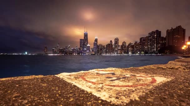 芝加哥美丽的天际线城市景观掠过时间 前方的水泥路面上没有白色磨损的跳水标志 建筑物和城市灯光照亮了浓重的云彩 — 图库视频影像