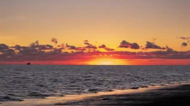 Panoramik turuncu ve sarı gündoğumu zamanlarında güneş ufukta bulutlara doğru yükselirken Michigan Gölü 'nün sularında yüzen kaz sürüsü gibi..