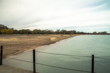 Chicago, IL - 3 Mayıs 2020: Güzel güneşli ve sıcak bir günde, kuzey tarafındaki Loyola Parkı 'nın kumlu sahilinde bir grup insan toplandı..