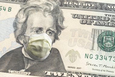 Amerikan kağıt para birimini kapatın. 20 dolarlık banknot. Andrew Jackson, COVID-19 salgınından dolayı sarı yüz maskesi takıyor. Krizin ortasında büyük bir finans ya da ekonomik geçmiş oluşturuyor..