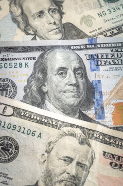 Bir Benjamin ya da bir Birleşik Devletler yüz dolarlık banknot, ekonomik ya da ticari bir geçmiş için bir masaya yayılmış yirmi ile elli dolar arasında bir banknot ya da kağıt para yatar..