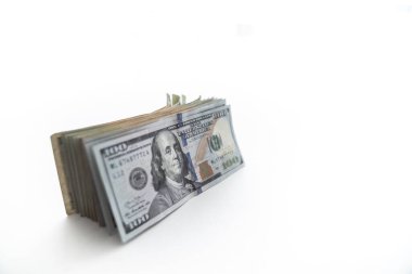 Yüz dolarlık banknot ya da Benjamin 'in üstteki beyaz arka planda kopyalanmış bir şekilde kaymaya başlamasıyla, büyük bir ABD kağıt para birimi ya da nakit yığını kenarda duruyor..