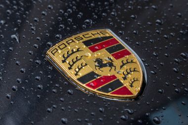 Porsche Logo Close Up yağmur damlaları ile siyah bir araba üzerinde.
