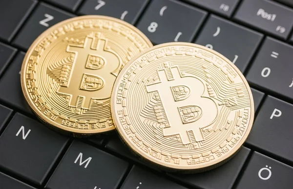 Digitale Währung physische goldene Bitcoin-Münzen auf schwarzem Computer — Stockfoto