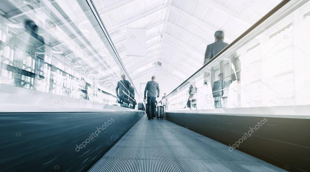 blurred commuters on a escalator