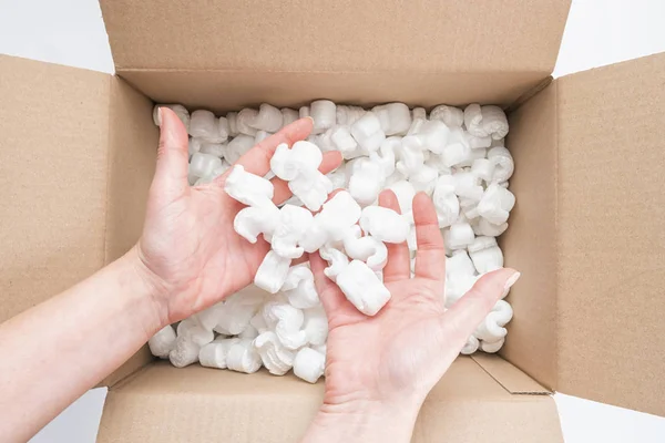 Primer plano de las manos femeninas sosteniendo montón de cacahuetes de embalaje en cartón — Foto de Stock