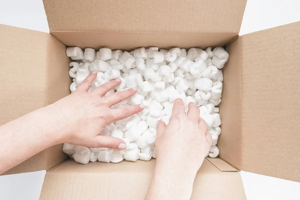 Primer plano de las manos femeninas cavando en un montón de cacahuetes de embalaje en — Foto de Stock