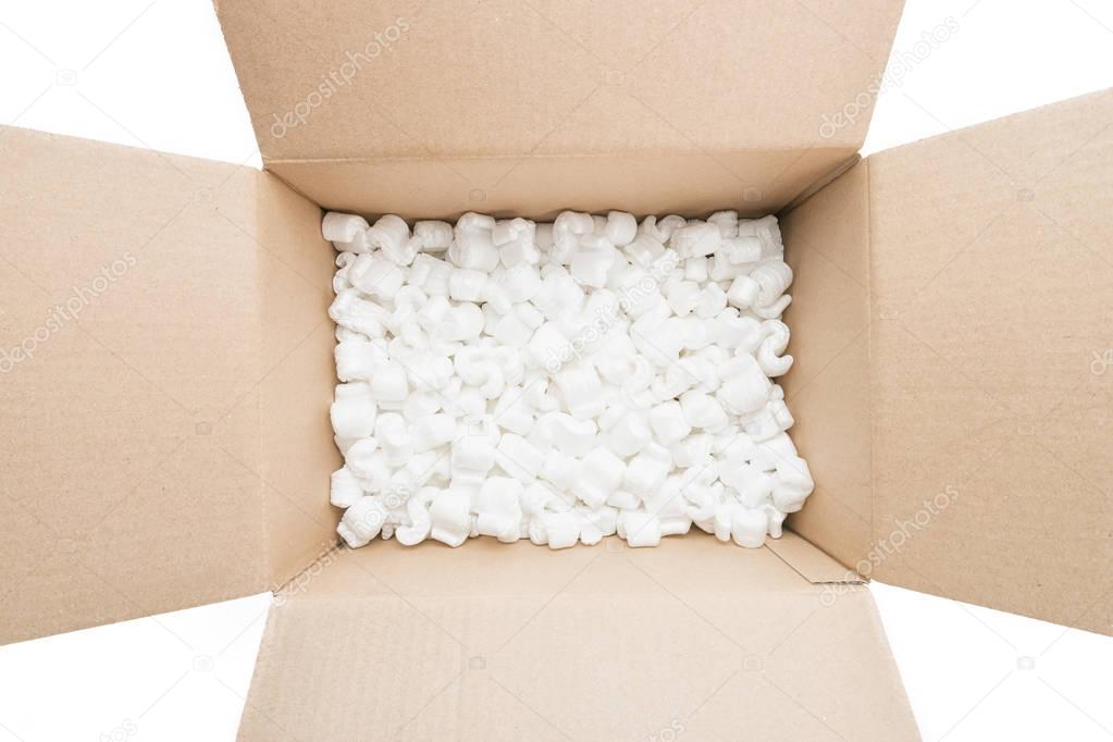 cardboard box with packing foam pellets top view, isolated on wh