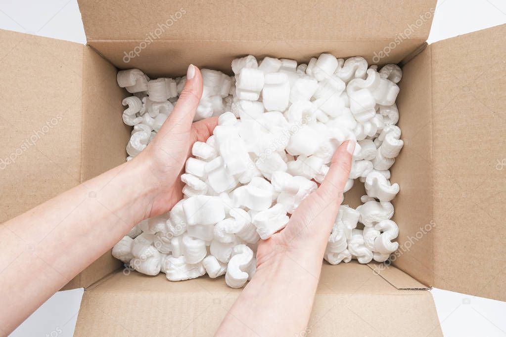 Closeup of female hands digging in a heap of packing peanuts in 