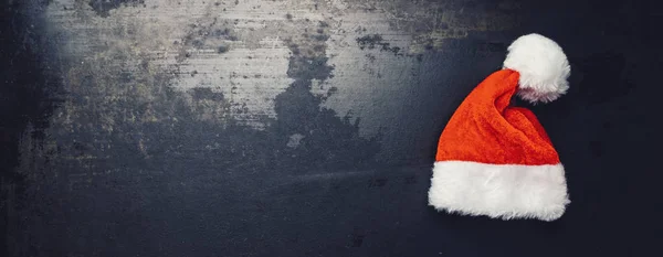 Christmas santa hat on a dark surface, including copy space — Stock Photo, Image