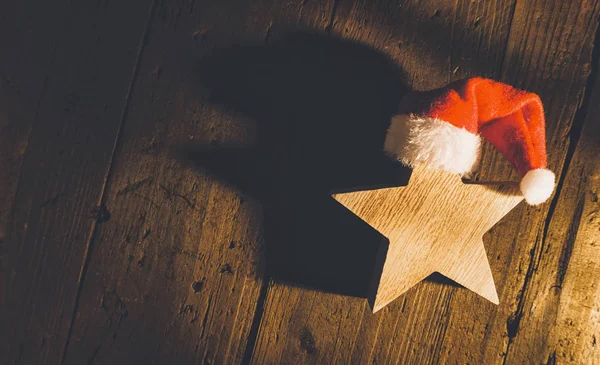 Karácsonyi csillag piros santa kalap, fa háttér includin — Stock Fotó