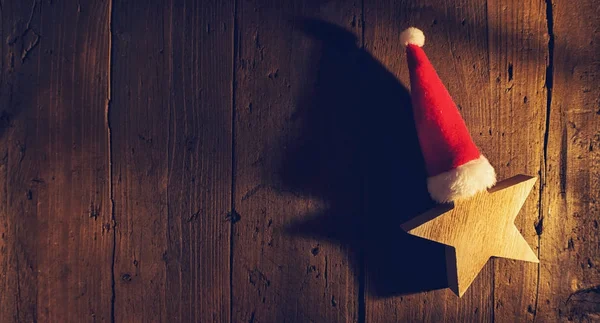 Karácsonyi csillag santa kalap, fa háttér, elegáns alacsony- — Stock Fotó