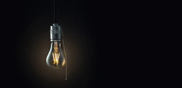 Old vintage hanging light bulb over dark background — Stock Photo, Image