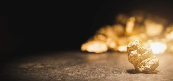 Золотой самородок перед курганом золота — стоковое фото