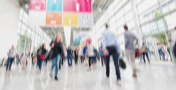 Intentionally blurred people walking trade show floor