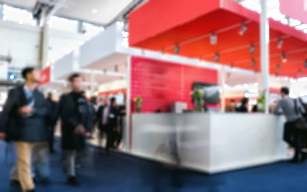 Business people walking in trade fair booth Intentionally blurre — Stock Photo, Image