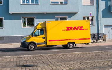 Sarı Dhl paket teslimat kamyonu sokakta park edilmiş.