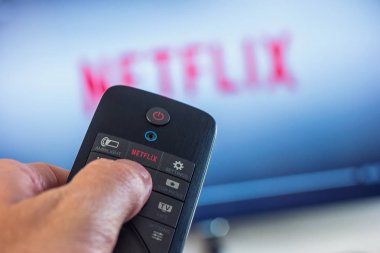 Adam bir uzaktan kumanda tutar ve bir film--dan Netflix seçer
