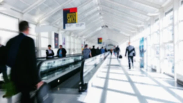 Passageiros de negócios desfocados andando em escadas em um aeroporto — Fotografia de Stock