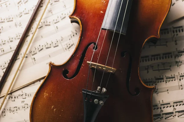 Gammal antik fiol med stråke på papperslappar — Stockfoto