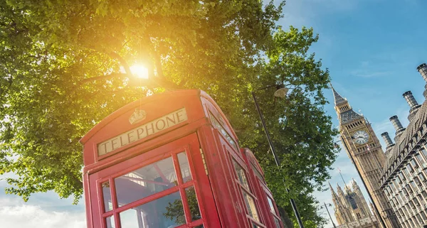 traditional red phone booth with big ben in the background at summer in london. ideal for websites and magazines layouts