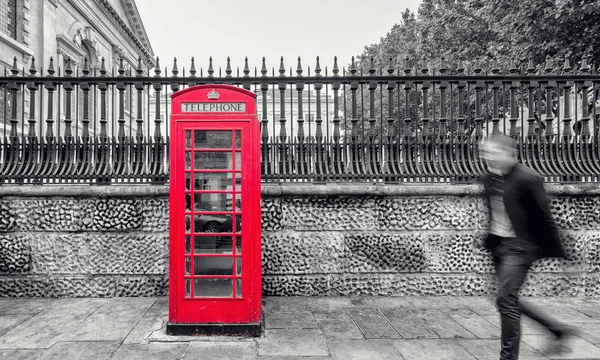 view of a red phone booth in the street of  london in black and white colors. ideal for websites and magazines layouts