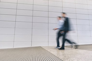 bir koridorda yürürken bulanık anonim iş adamları