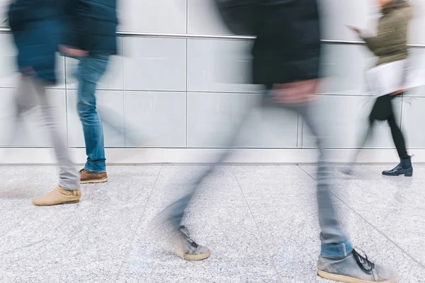 blurred anonymous pedestrian walking in a floor