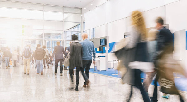 blurred people rushing at a trade fair hall