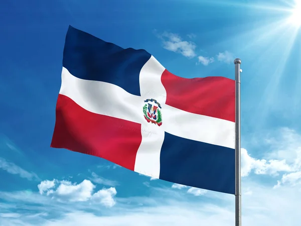 Доминиканский флаг, размахивающий в голубом небе — стоковое фото