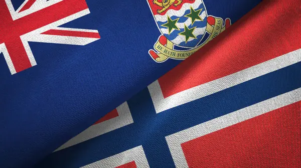 Kaaimaneilanden en Noorwegen twee vlaggen textiel doek, stof textuur — Stockfoto