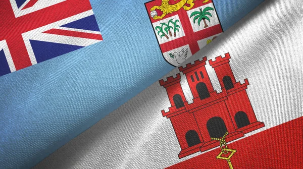 Fiji y Gibraltar dos banderas tela textil, textura de la tela —  Fotos de Stock