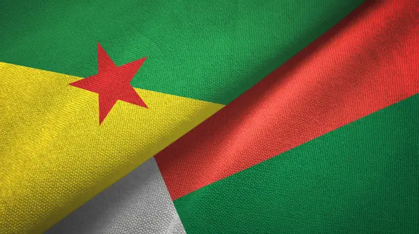 Französisch Guiana und Madagaskar zwei Flaggen Textilstoff, Textur — Stockfoto