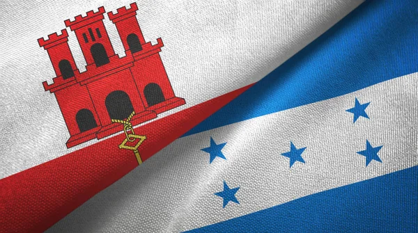 Gibraltar e Honduras duas bandeiras de pano têxtil, textura de tecido — Fotografia de Stock