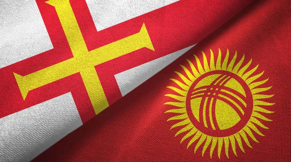 Guernsey y Kirguistán dos banderas tela textil, textura de la tela — Foto de Stock