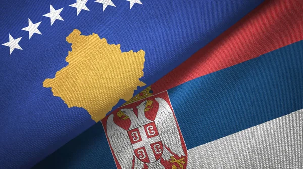 Kosovo e Sérvia duas bandeiras pano têxtil, textura de tecido — Fotografia de Stock