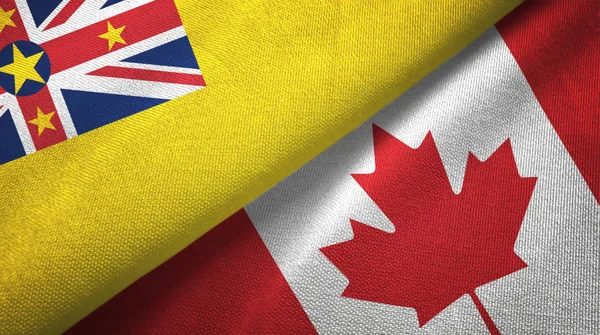Niue en Canada twee vlaggen textiel doek, stof textuur — Stockfoto