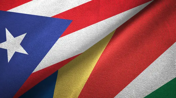 Puerto Rico en de Seychellen twee vlaggen textiel doek, stof textuur — Stockfoto