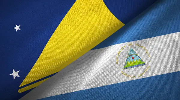 Tokelau en Nicaragua twee vlaggen textiel doek, stof textuur — Stockfoto