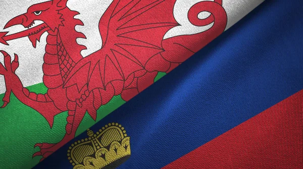 País de Gales e Liechtenstein duas bandeiras de pano têxtil, textura de tecido — Fotografia de Stock