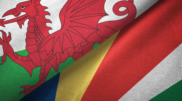 País de Gales e Seychelles duas bandeiras pano têxtil, textura de tecido — Fotografia de Stock