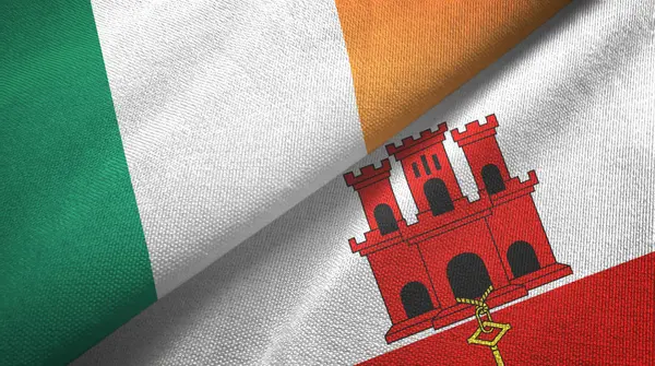 Irlanda y Gibraltar dos banderas tela textil, textura de la tela —  Fotos de Stock