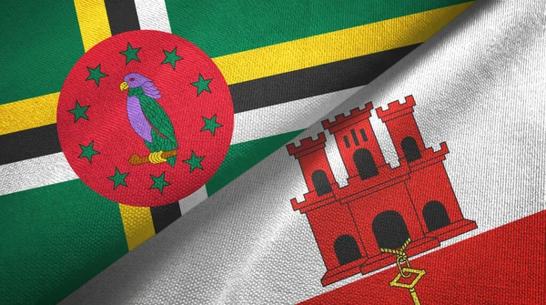 Dominica en Gibraltar twee vlaggen textiel doek, stof textuur — Stockfoto