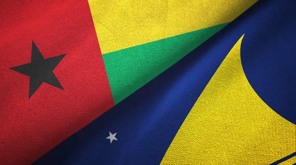 Guinee-Bissau en Tokelau twee vlaggen textiel doek, stof textuur — Stockfoto