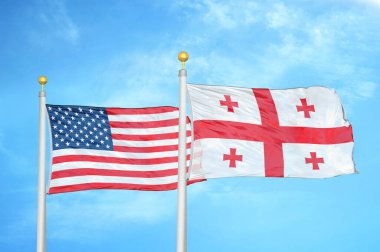 ABD ve Gürcistan bayrak direkleri ve mavi bulutlu arka planda iki bayrak