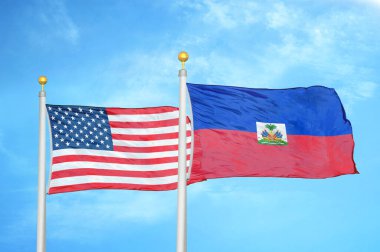 ABD ve Haiti bayrak direkleri ve mavi bulutlu arka planda iki bayrak