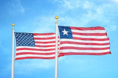 ABD ve Liberya bayrak direkleri ve mavi bulutlu arka planda iki bayrak